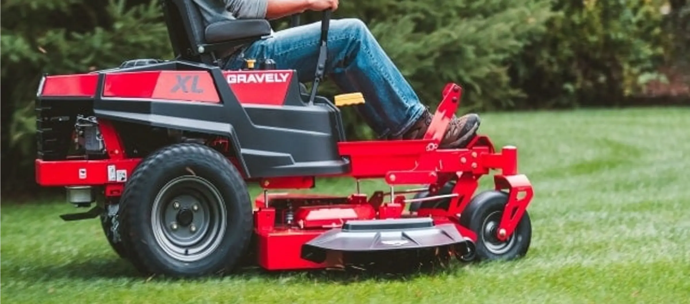 worker mowing lawn
